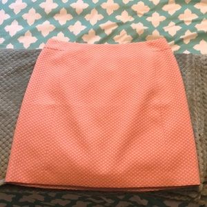 a pink/salmon pencil skirt with slight polka dots